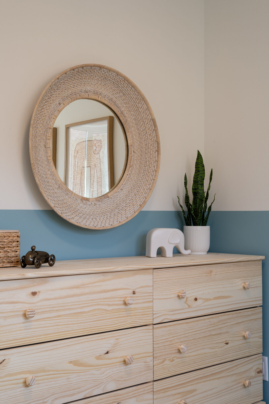 Urban Collection bedroom dresser: woven round mirror over a natural pine dresser against a two-tone sand and blue wall